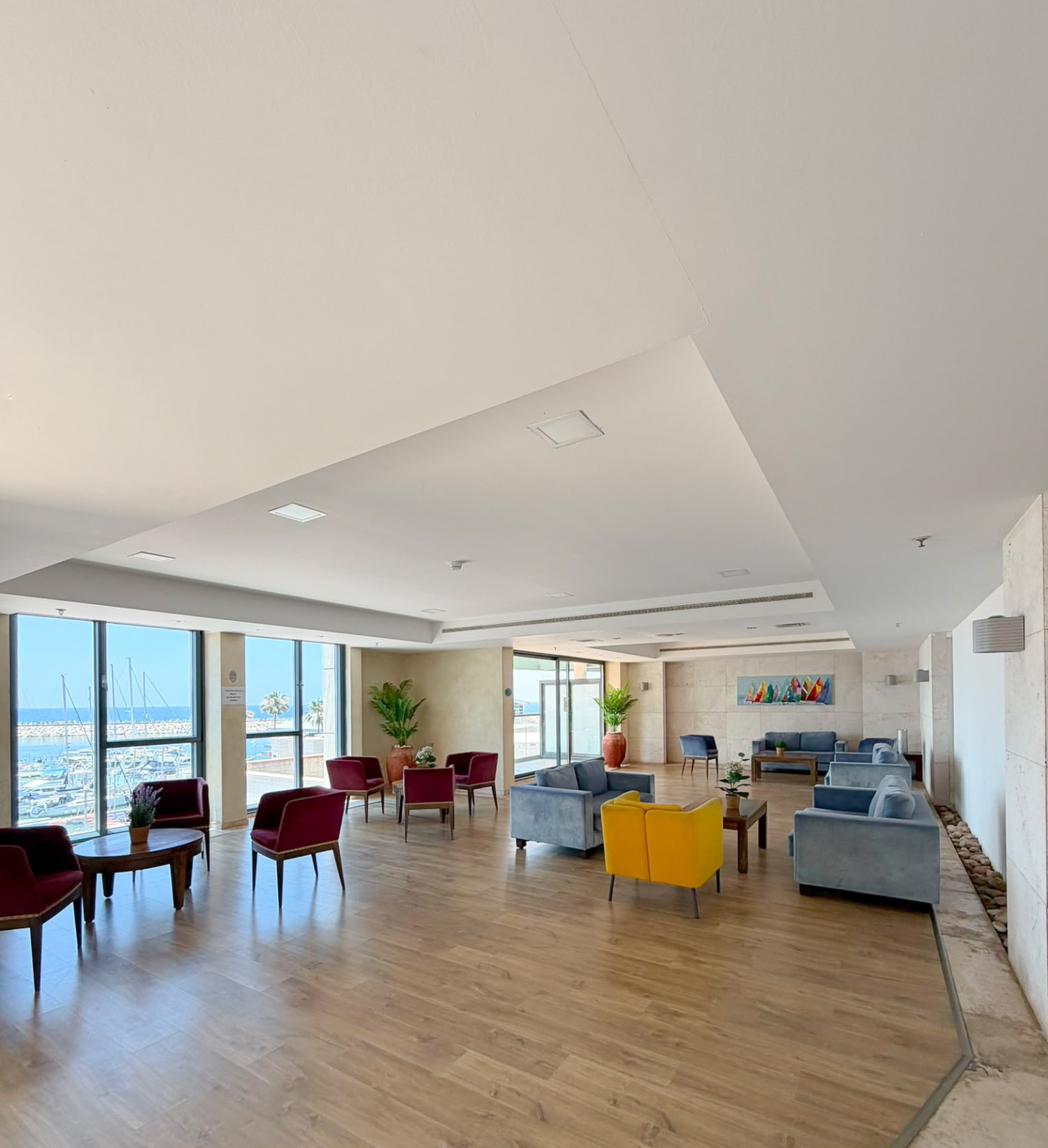 Open-space residents' lounge with seating areas overlooking the marina