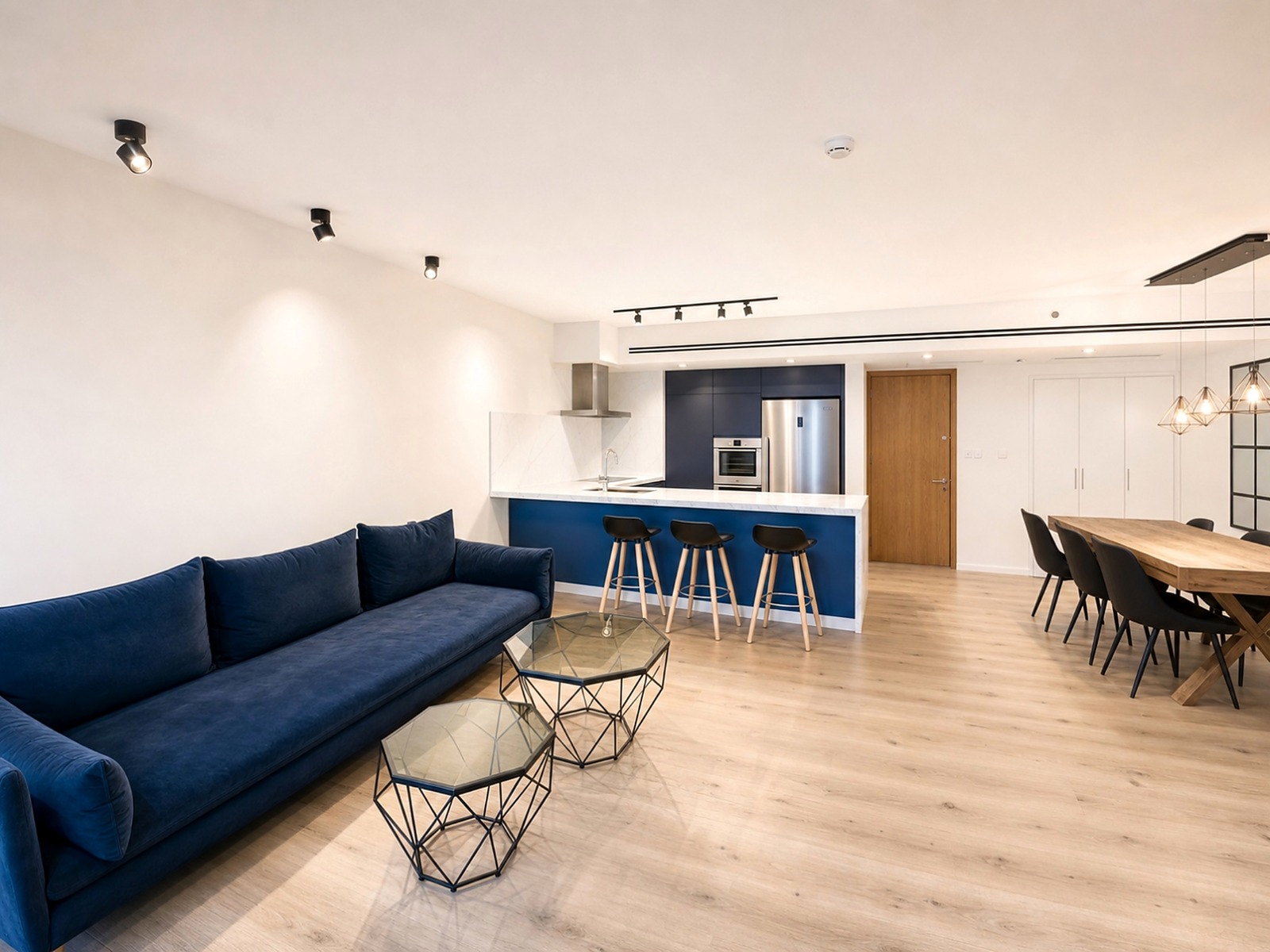 Open-plan living, dining and kitchen area with navy joinery and oak flooring
