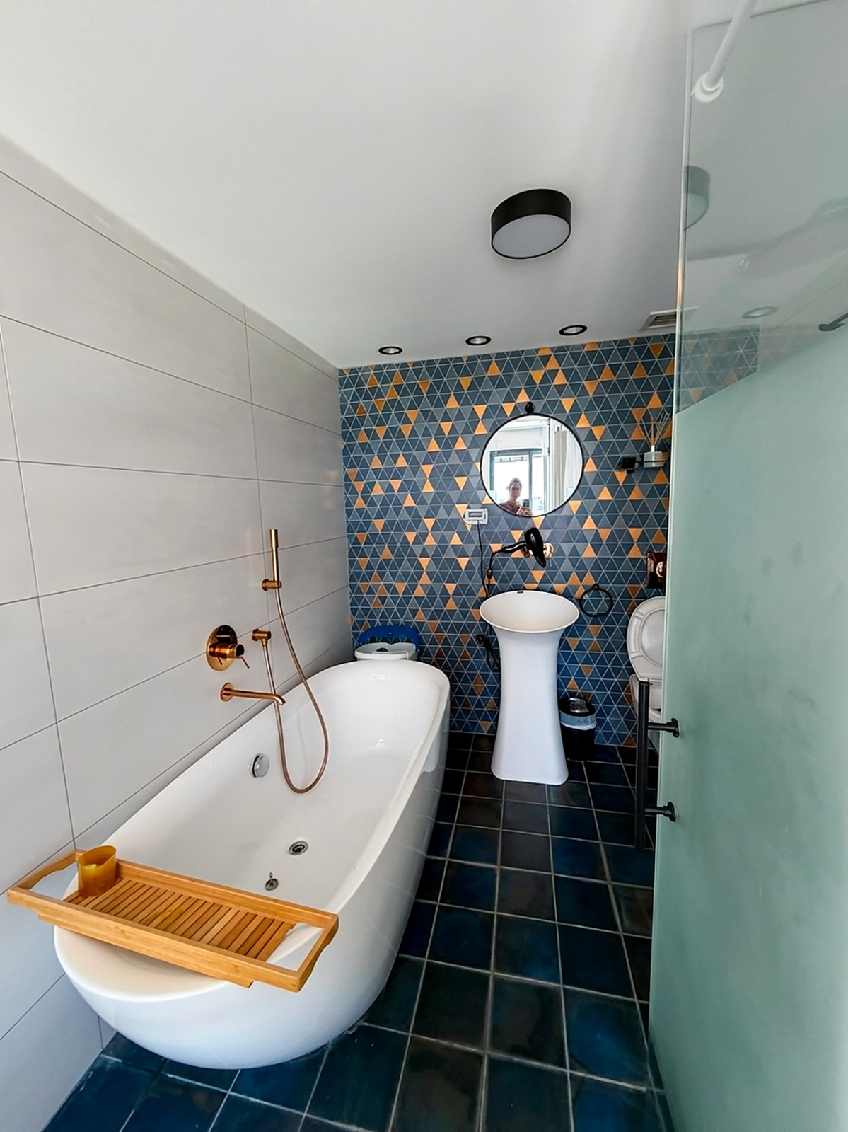 Upgraded bathroom with freestanding bath and patterned feature wall